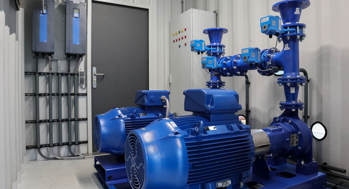 Close up van 2 hogedrukpompen, frequentieregelaars, kleppen en schakelkast